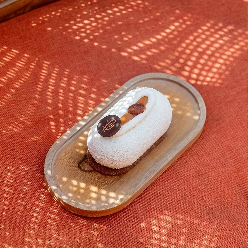 Entremets banoffee au monogramme en chocolat, sur un plateau en bois