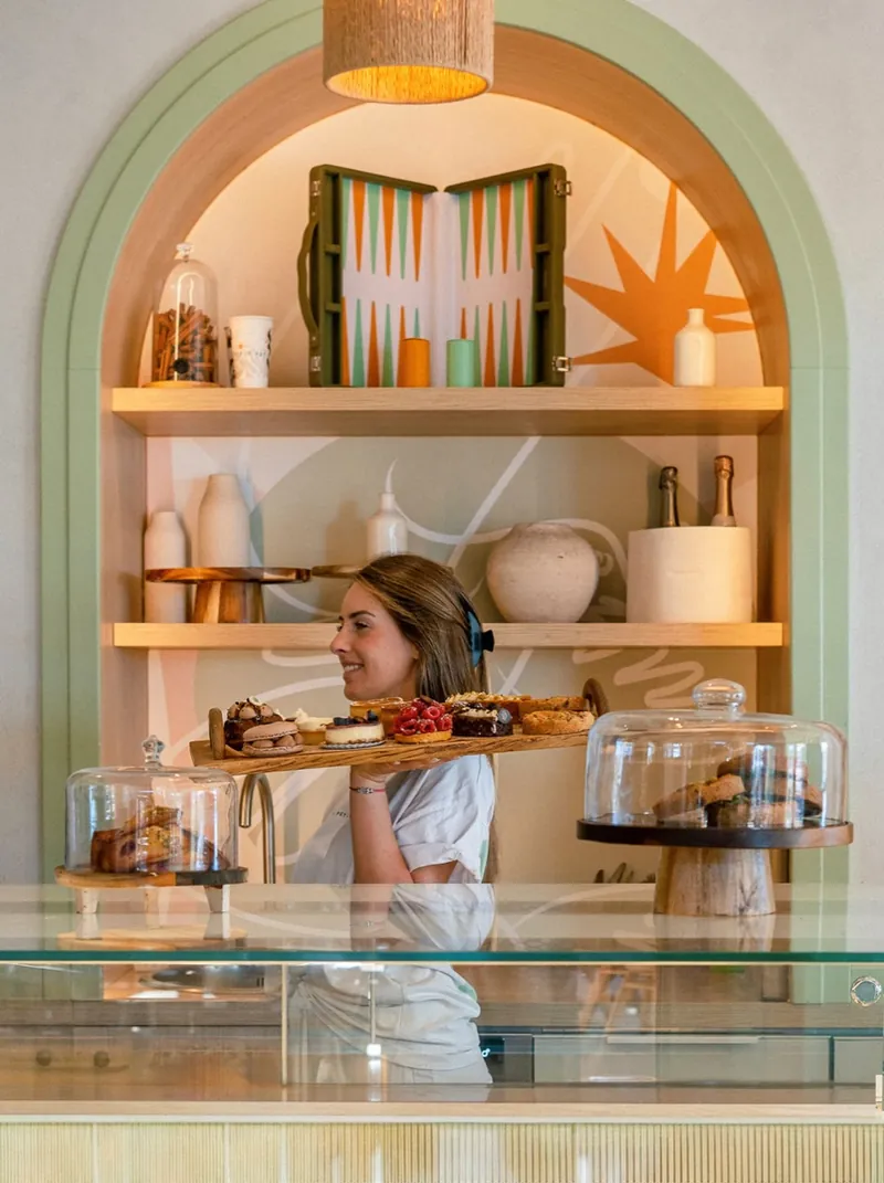 Le comptoir de la pâtisserie sous l’arche vert sauge